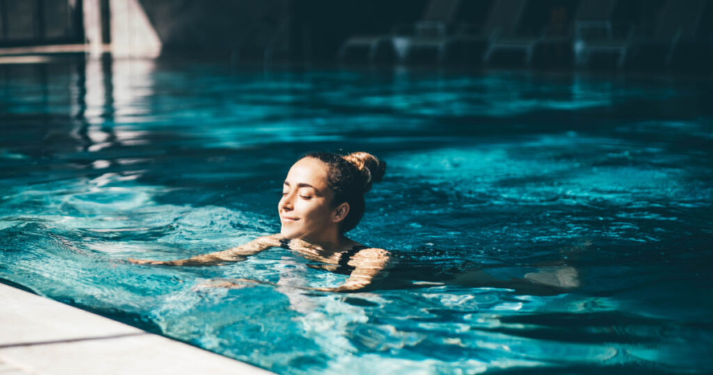 Woman relaxing in the swimming pool.
