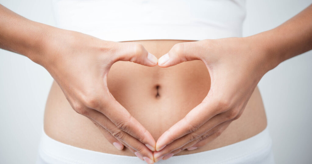 Close up of woman's hands made heart on belly isolated on white background.health care concept. 