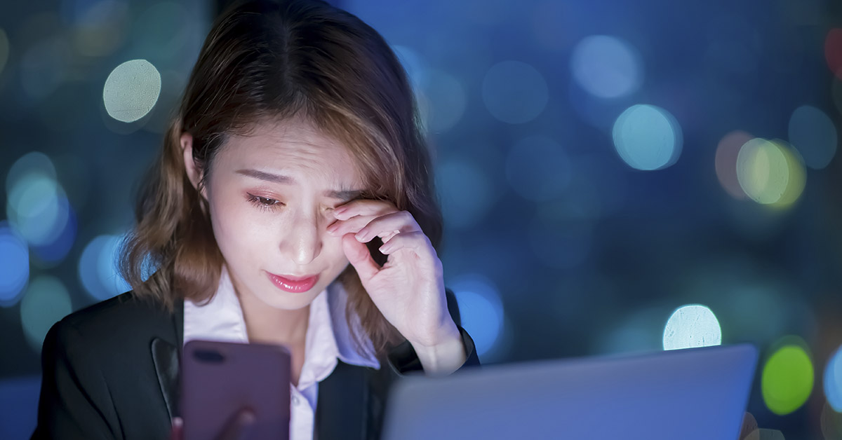 woman staring at computer screen rubbing eye. Technology fatigue concept
