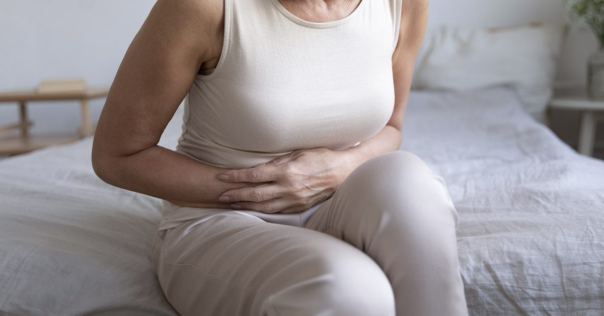 woman holding gut in pain