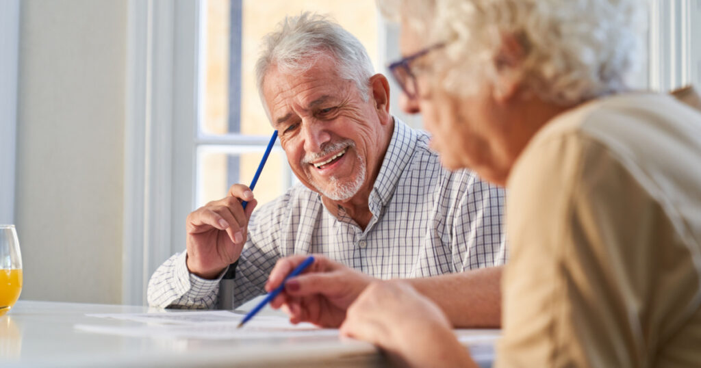 Couple of seniors has fun solving puzzles as a memory training against Alzheimer's and dementia
