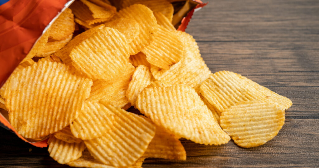 Potato chips, delicious BBQ seasoning spicy for crips, thin slice deep fried snack fast food in open bag.

