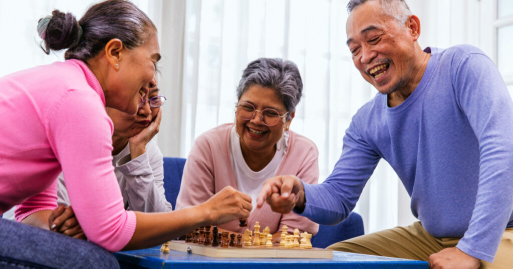 Person playing chess board game. Older Man playing chess. Hand of Senior man moving chess in success play. strategy, Management or leadership concept. concept of business strategy and tactic
