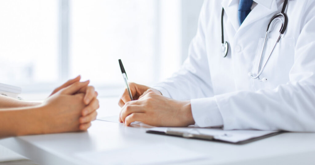 close up of patient and doctor taking notes
