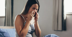 woman placing hands over sinuses on face. Sinus infection concept