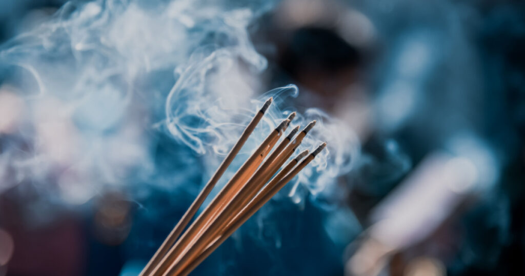 Hand holding incense sticks for worship, Close up shot
