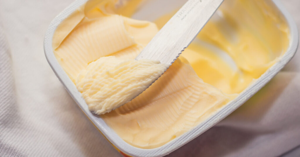 taking margarine from the jar with the knife
