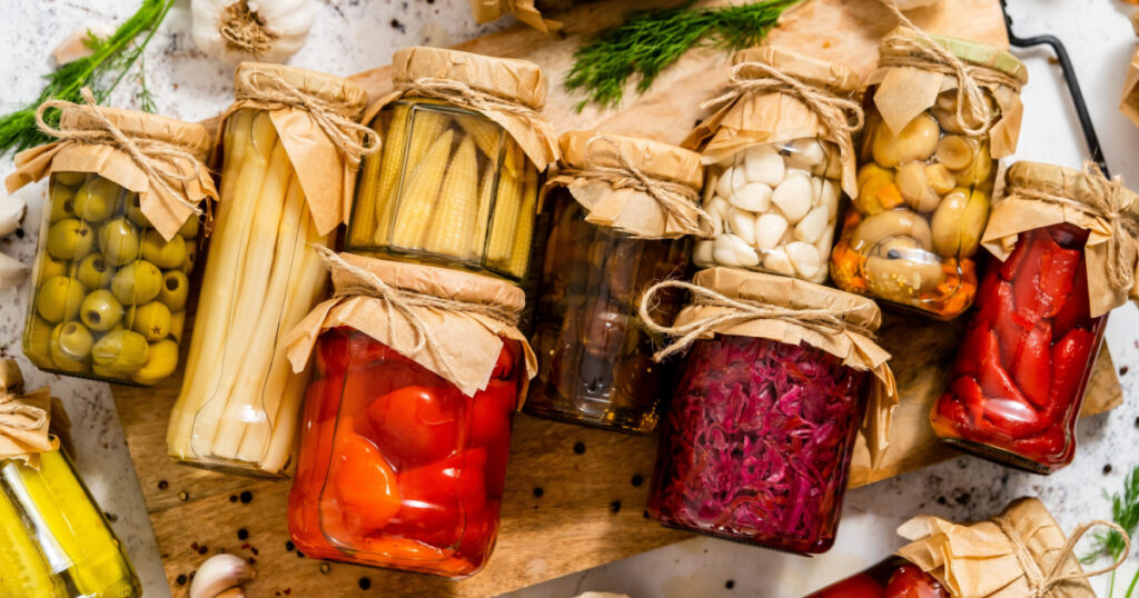Various kinds preserves vegetables and mushrooms in glass jars.
