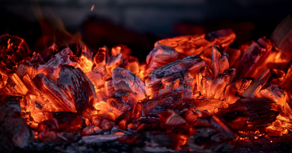 Flame of fire from hot burning coals in the fireplace. Heat from the oven. High quality photo
