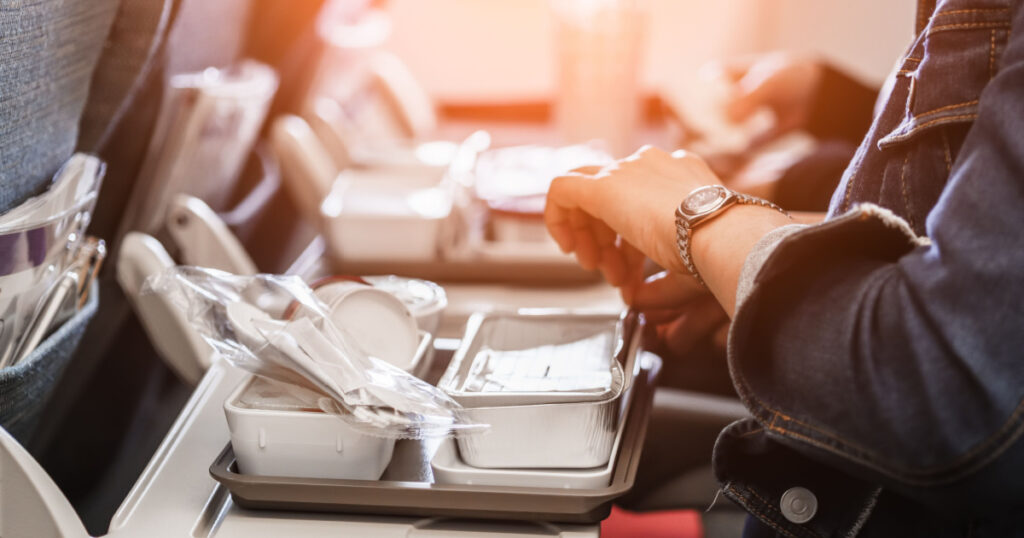 woman passengers eats lunch in travel aboard of international flight
