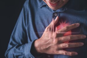 man with hand placed over chest. Heart attack and heart disease symptoms concept