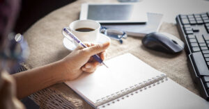 Are Left-Handed People Truly Smarter Than Everyone Else? left handed person writing in notebook