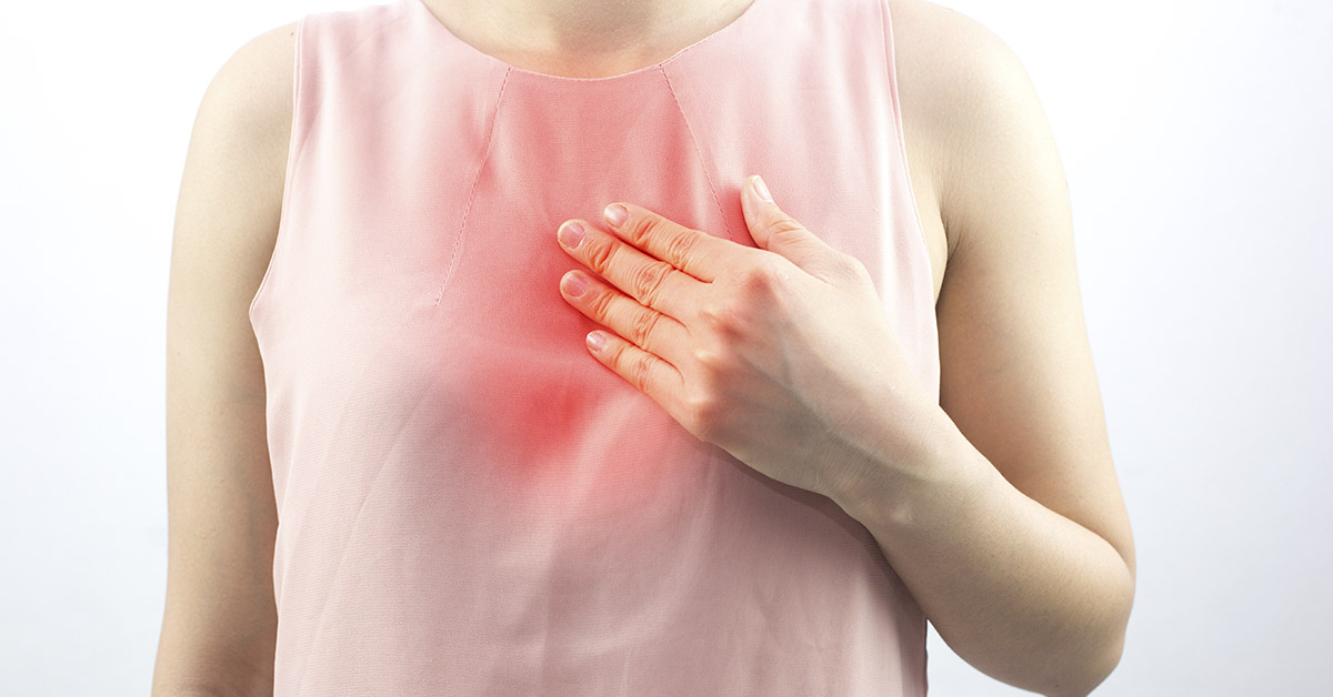 woman holding chest with radiating redness. Heartburn, acid reflux concept