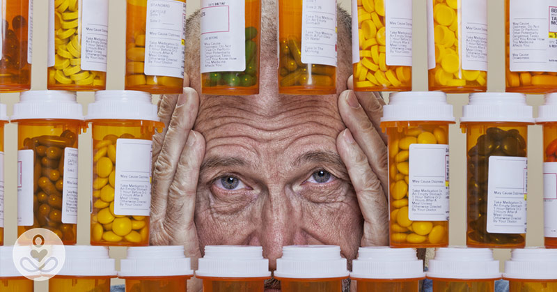 elderly person surrounded by medication bottles