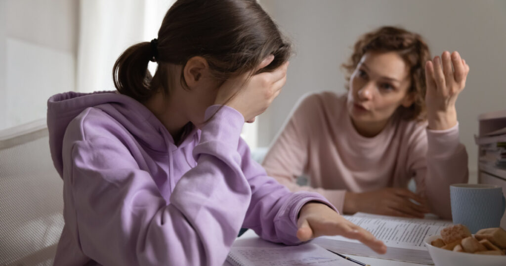 Angry adult mother scolding lazy teen daughter for bad school results at home. Frustrated mum talking to upset teenage girl arguing disciplining child must study. Parent and children conflicts concept