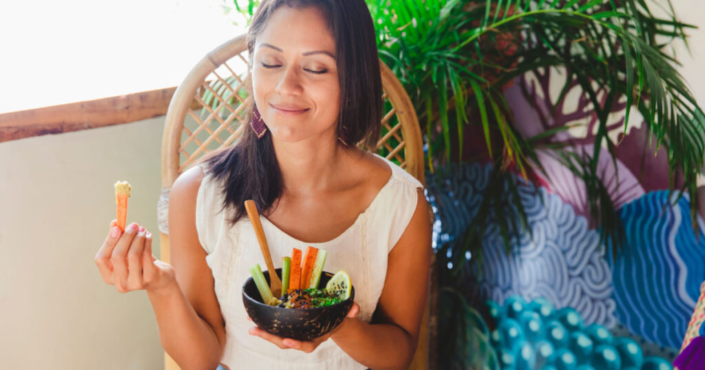 Woman on an organic vegan restaurant, eating a hummus.
