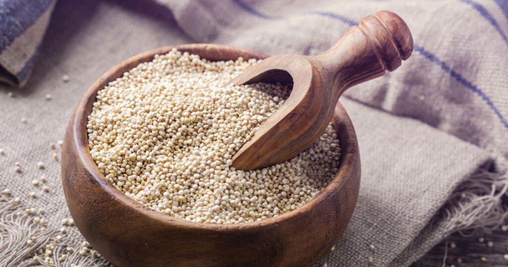 White quinoa seeds on a wooden background