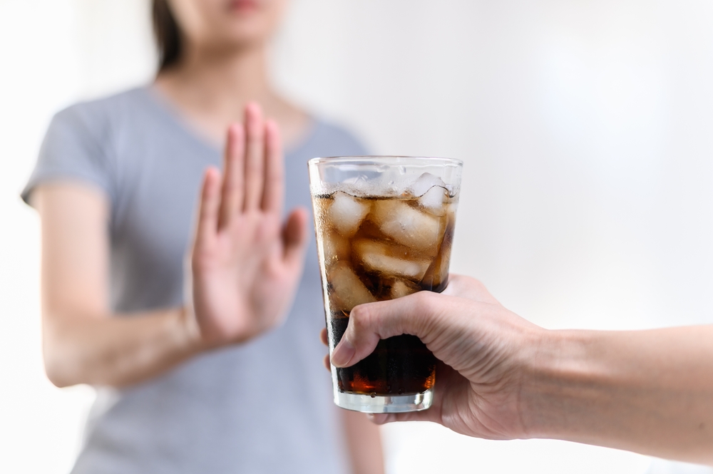 Dieting or good health concept. Young woman rejecting Junk food or unhealthy food such as sweet soda drink and choosing healthy food such as fresh fruit or vegetable.