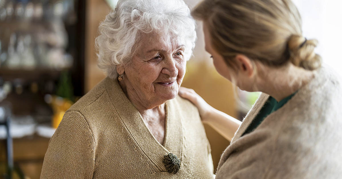 woman consoling an elderly woman with dementia
