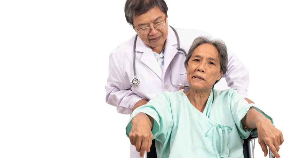 Asian elderly woman with a paralysis, stroke or cerebrovascular accident (CVA) symtoms sitting on wheelchair and the doctor take care. Elderly health care.