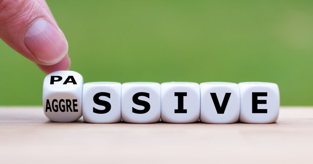 Hand turns a dice and changes the word "passive" to "aggressive", or vice versa.