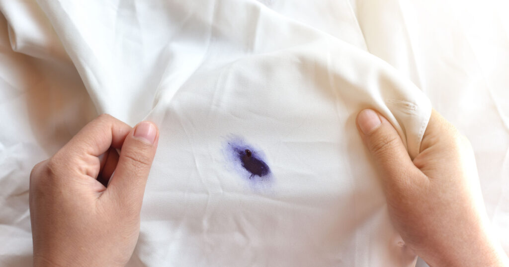 Dirty pen ink stain on fabric from accident in daily life. Concept of cleaning stains on clothes or cleaning the house. Selected focus