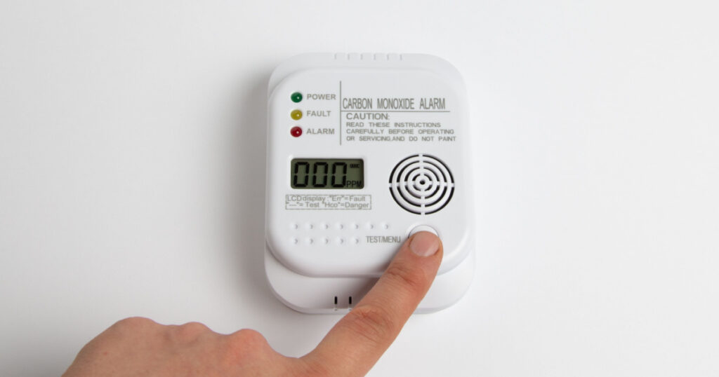 Testing carbon monoxide detector on a white wall. Stay home safe. Home control and security. CO detector