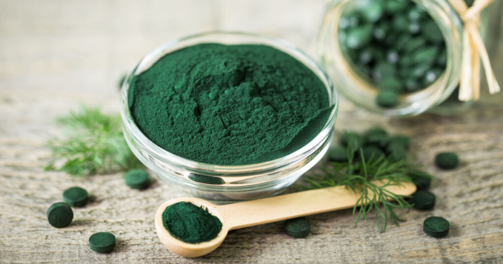 Spirulina powder and tablets in the bowl