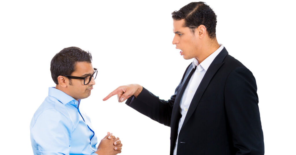 Closeup portrait of rude, mad, giant business man threatening, pointing at his nerdy guy coworker, isolated on white background. Negative emotion facial expression feelings. Office conflict resolution