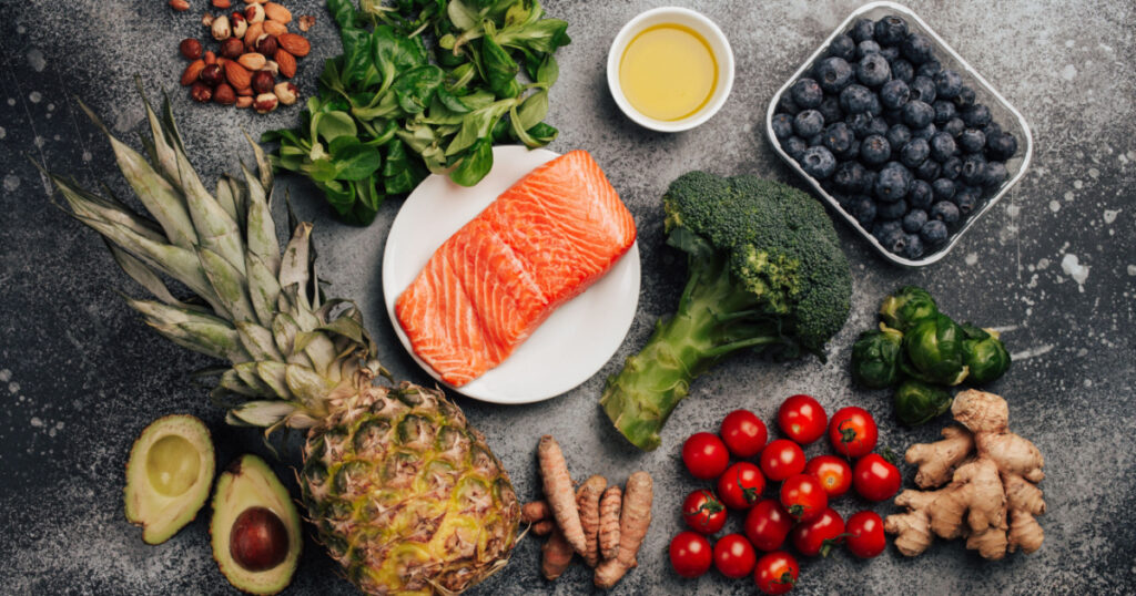 Anti inflammatory diet concept. Set of foods that help to reduce inflammation - plant based ingredients, fresh fruit, green vegetables. Healthy diet products, top view, stone background. Toned