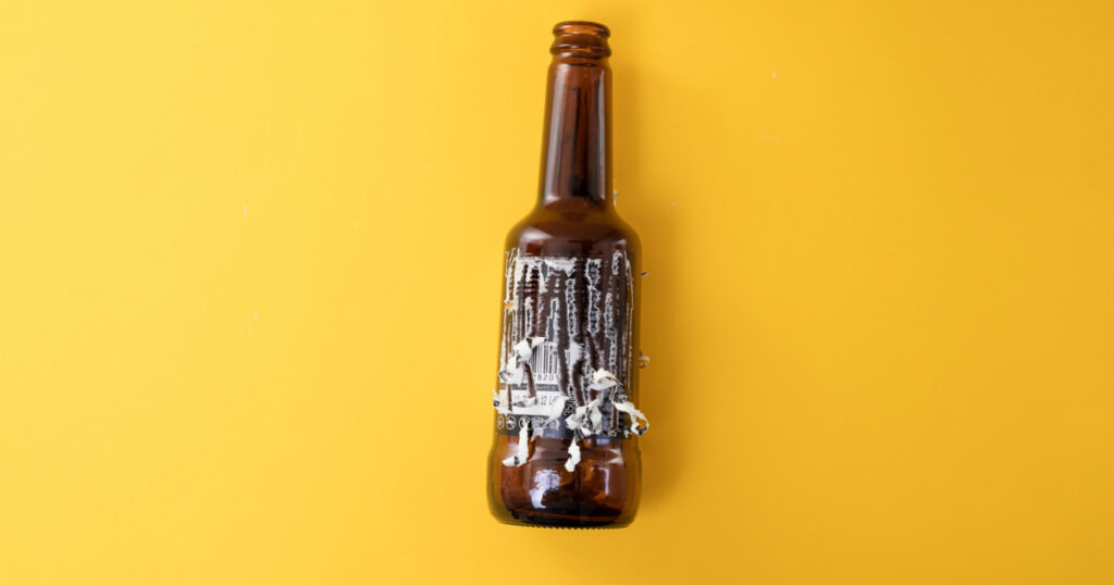 Removing sticky paper label from a glass beer bottle, recycling glass