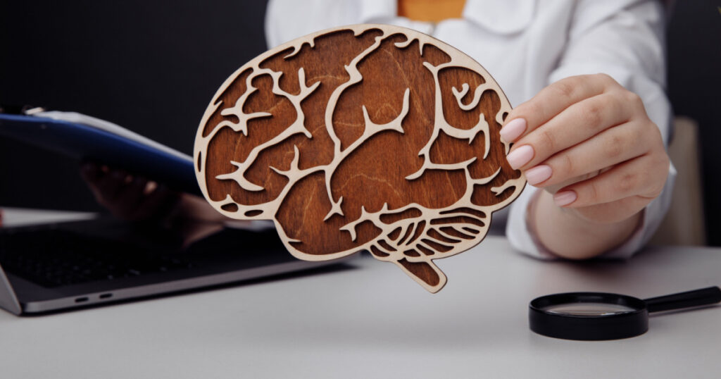 Doctor holding wooden brain. The importance of early diagnosis concept