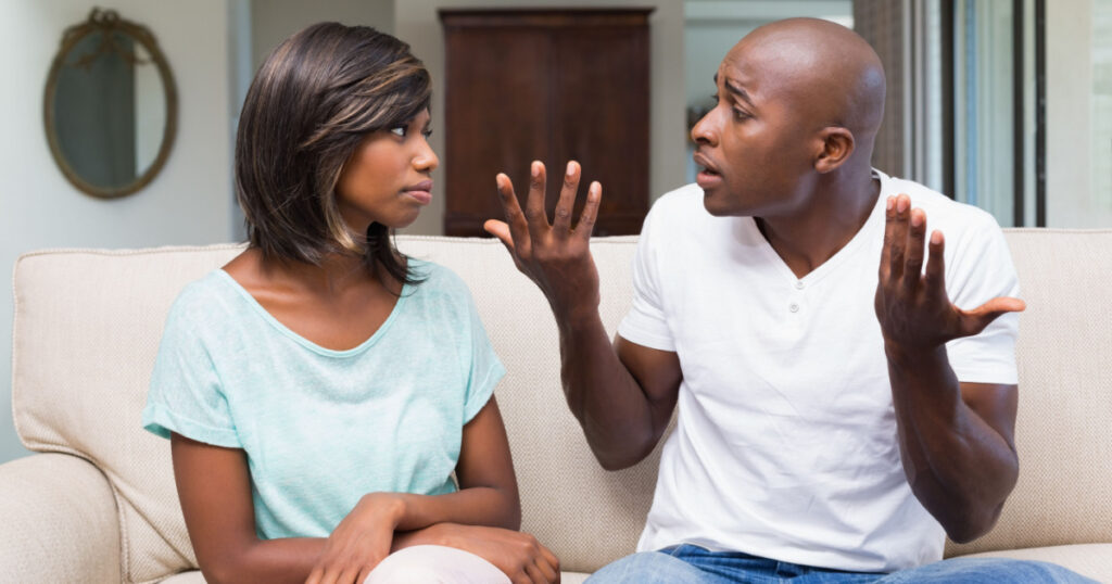 Unhappy couple having an argument on the couch at home in the living room