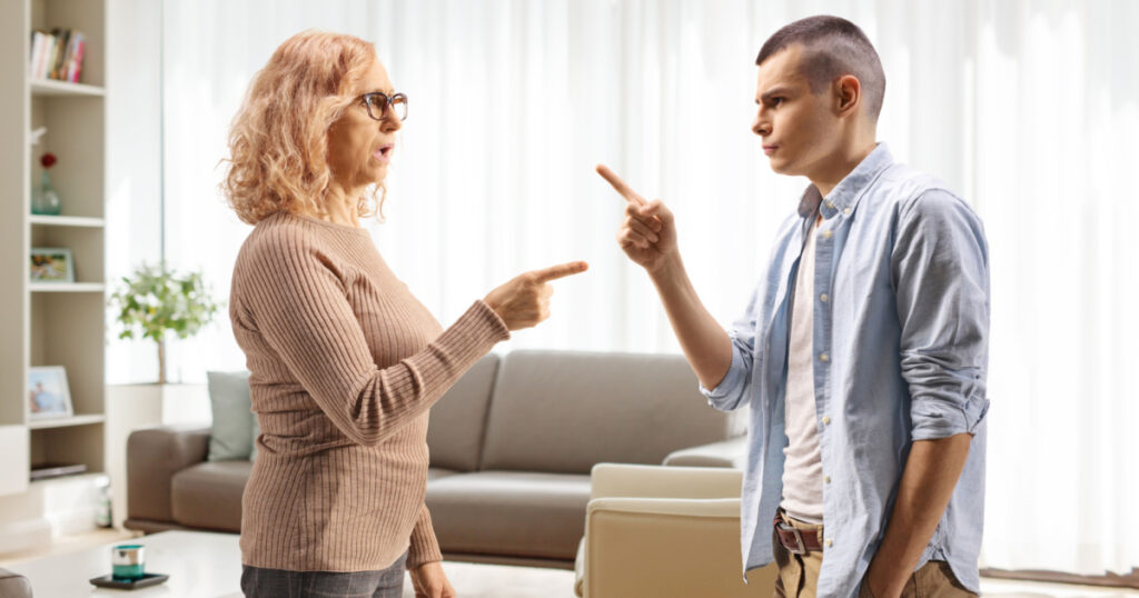 Profile shot of a mother arguing with son at home in a living room