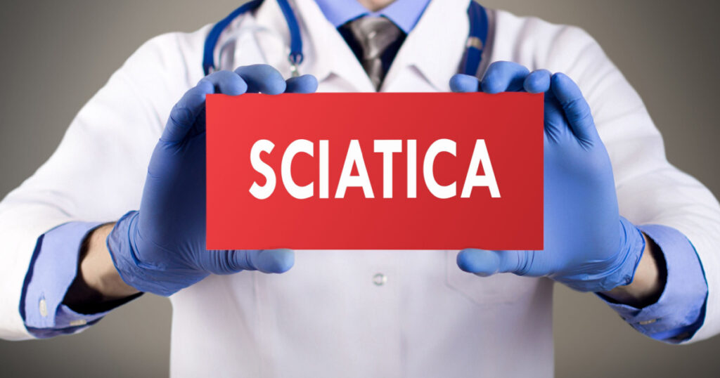 Doctor's hands in blue gloves shows the word sciatica. Medical concept.