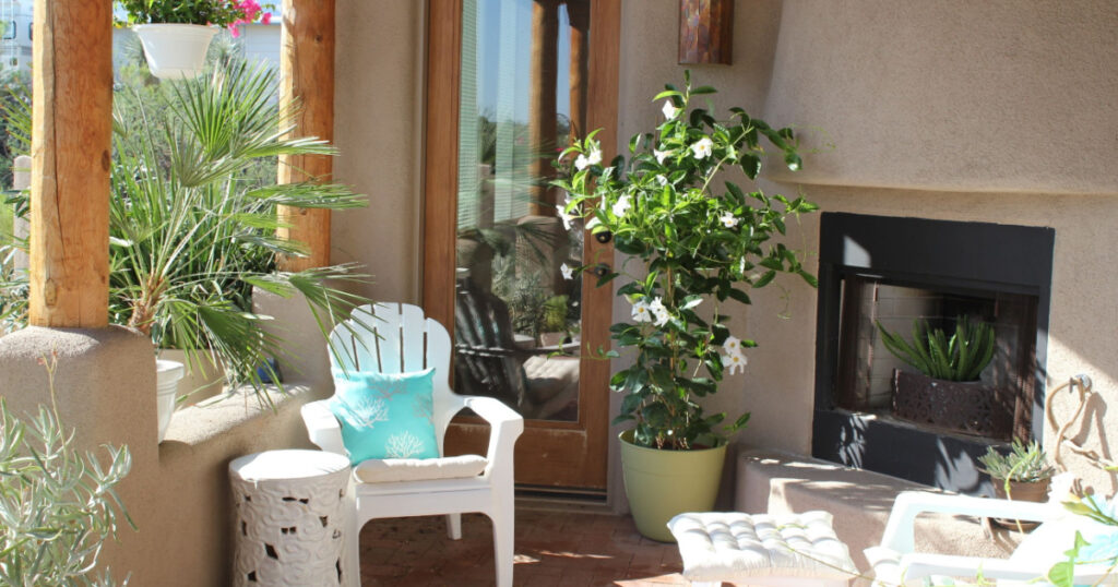 Outdoor spa life deck decor with fireplace, white chairs and plants on a sunny day in the Tucson Arizona desert
