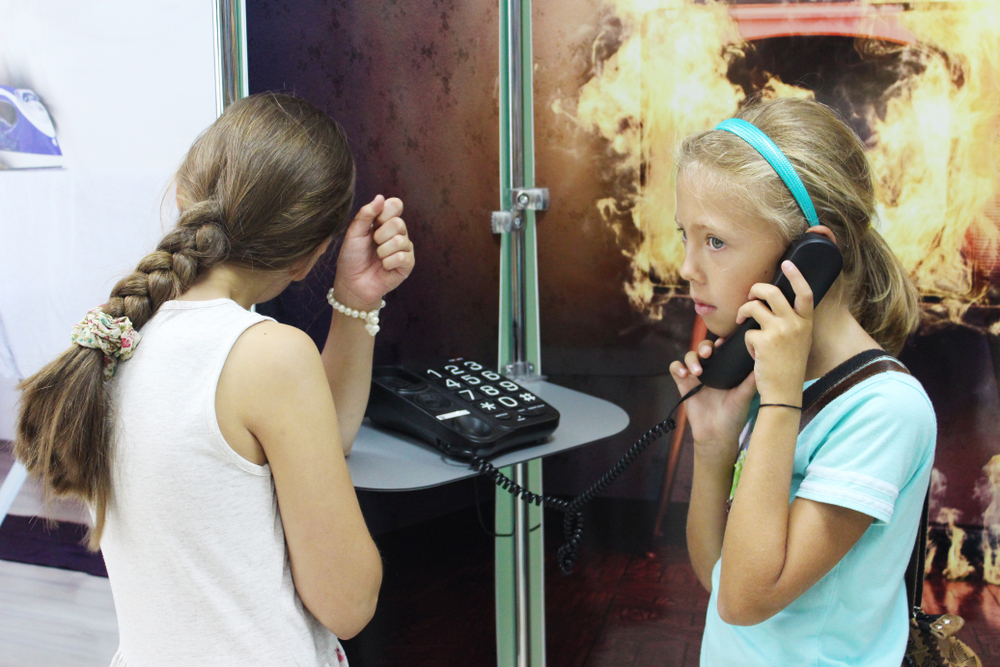VITEBSK, BELARUS - JULY 13, 2018. Children are in the Centre for Safety, learning how to behave in case of emergency situations. Interactive learning how to dial an emergency number in case of fire.