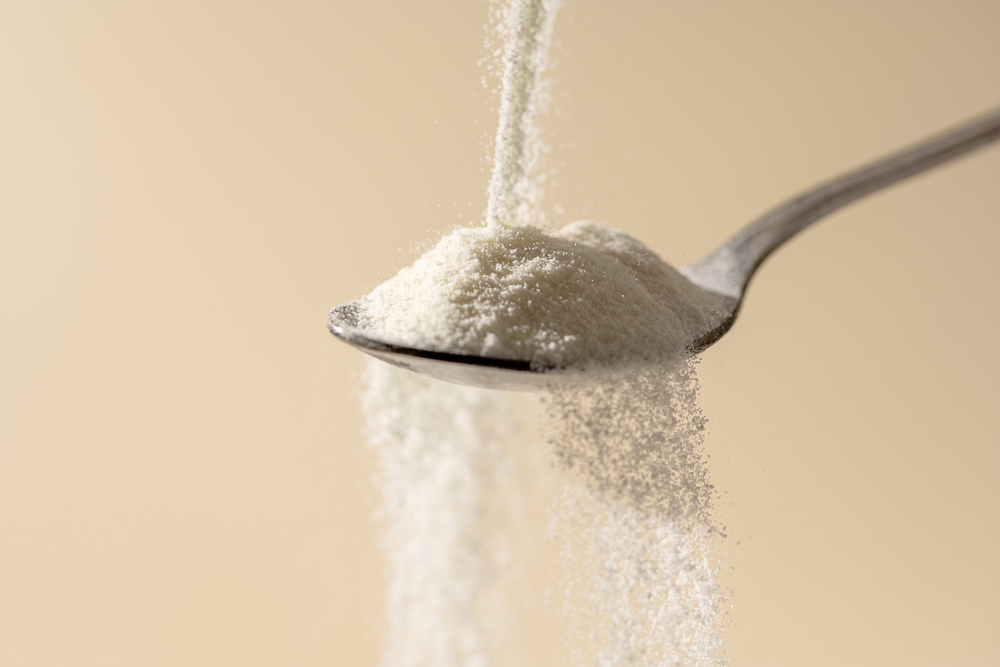 Collagen protein powder pouring in a spoon. Food beauty and health supplement