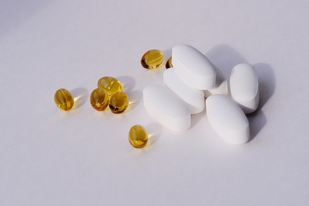 vitamin d capsules and magnesium citrate tablets close-up on a white background. dietary supplements
