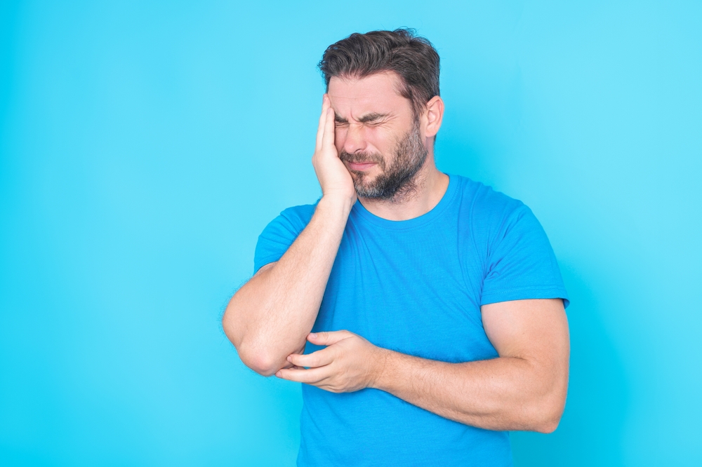 Sad man got migraine touches her head. Man with strong headache. Stressed, tired man from headache. Handsome man with hand on head, headache because stress. Suffering migraine.