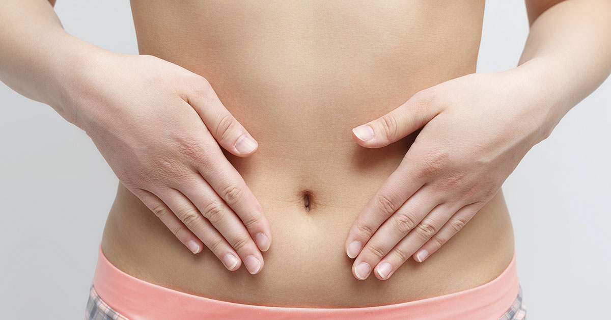 woman with hands placed on abdomen around navel