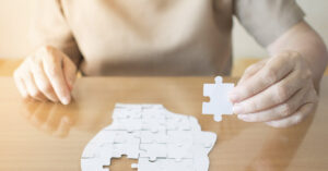 person putting together puzzle of human head. Dementia concept