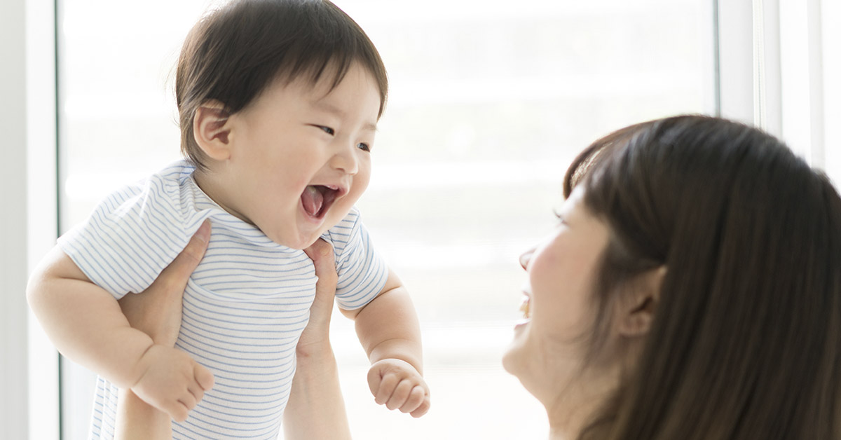 mother holding smiling infant