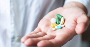 39 Common Medications That Can Have Potentially Detrimental Side Effects hand holding various medications