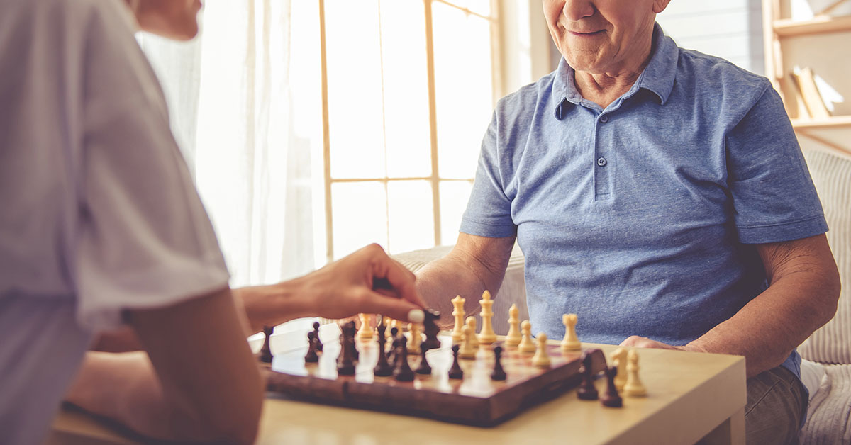 elderly friends playing chess