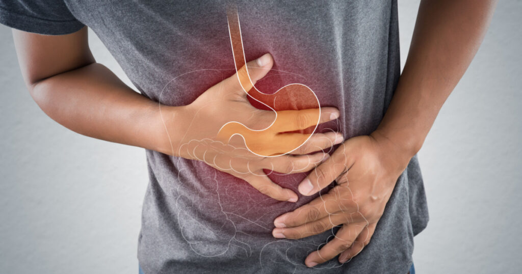 Acid reflux or Heartburn, The photo of stomach and internal organs is on the men's body against gray background, Stomach ache, Bad health, Male anatomy concept.