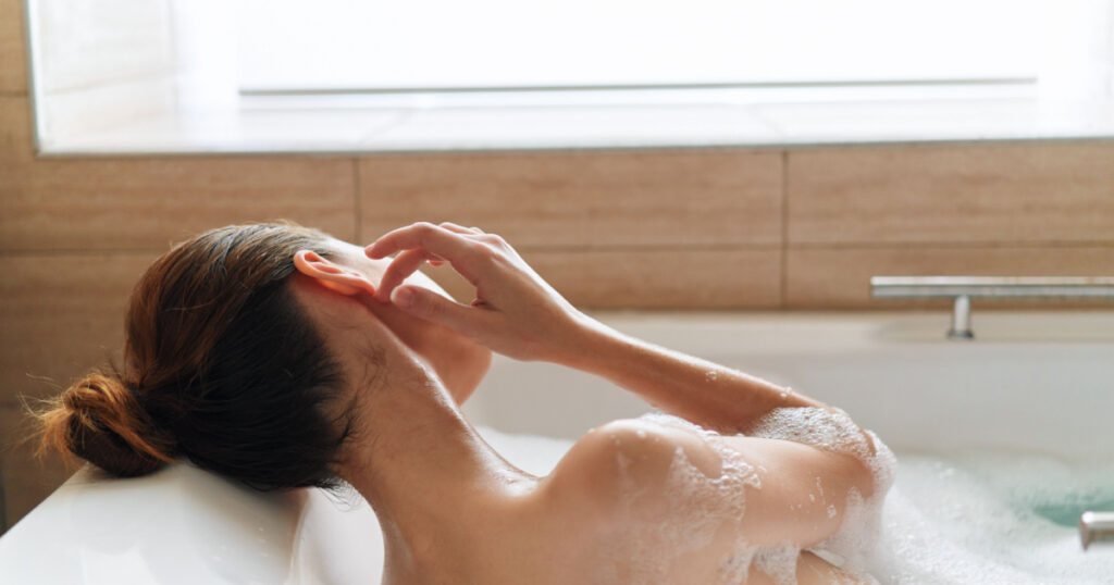 Beautiful woman naked shoulders bathroom spa treatments clean skin