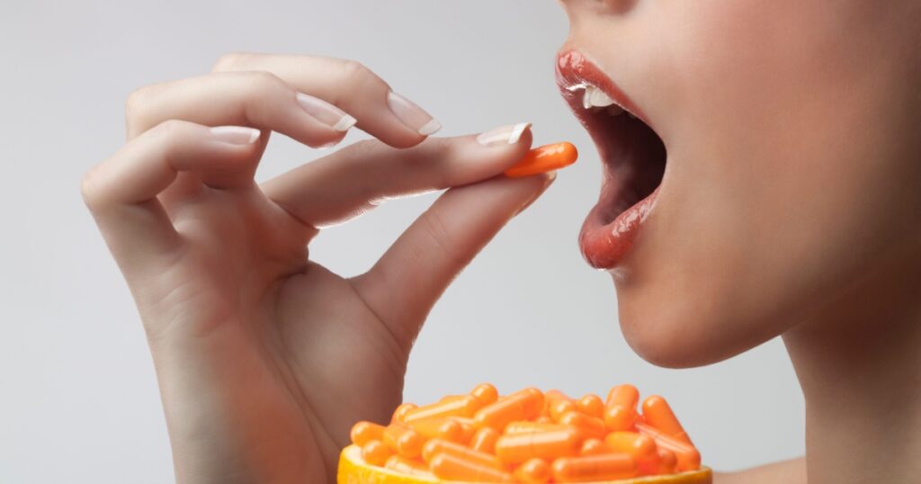 A woman taking vitamin c tablets