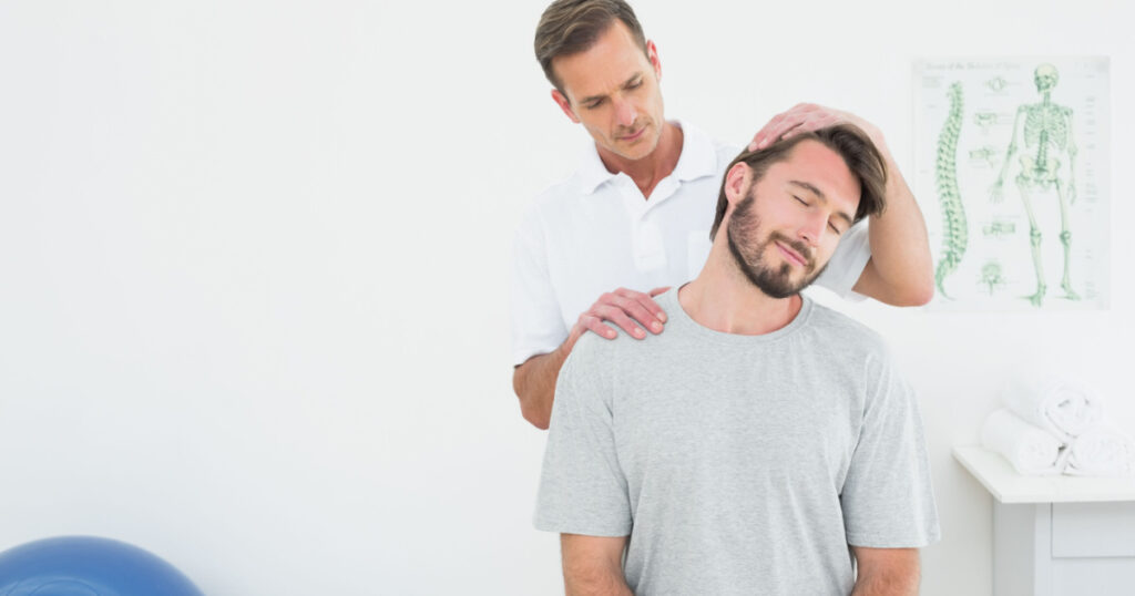 Male chiropractor doing neck adjustment in the medical office