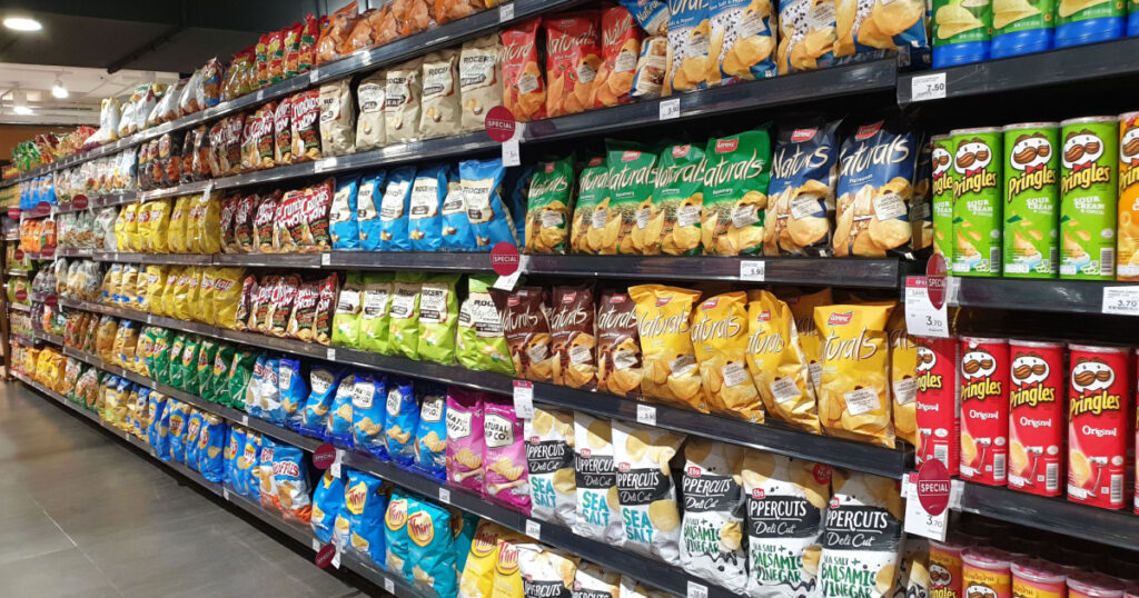 PENANG, MALAYSIA - 8 JULY 2020: Various local and imported brands of flavoured chips and snacks on store shelf in Mercato grocery store